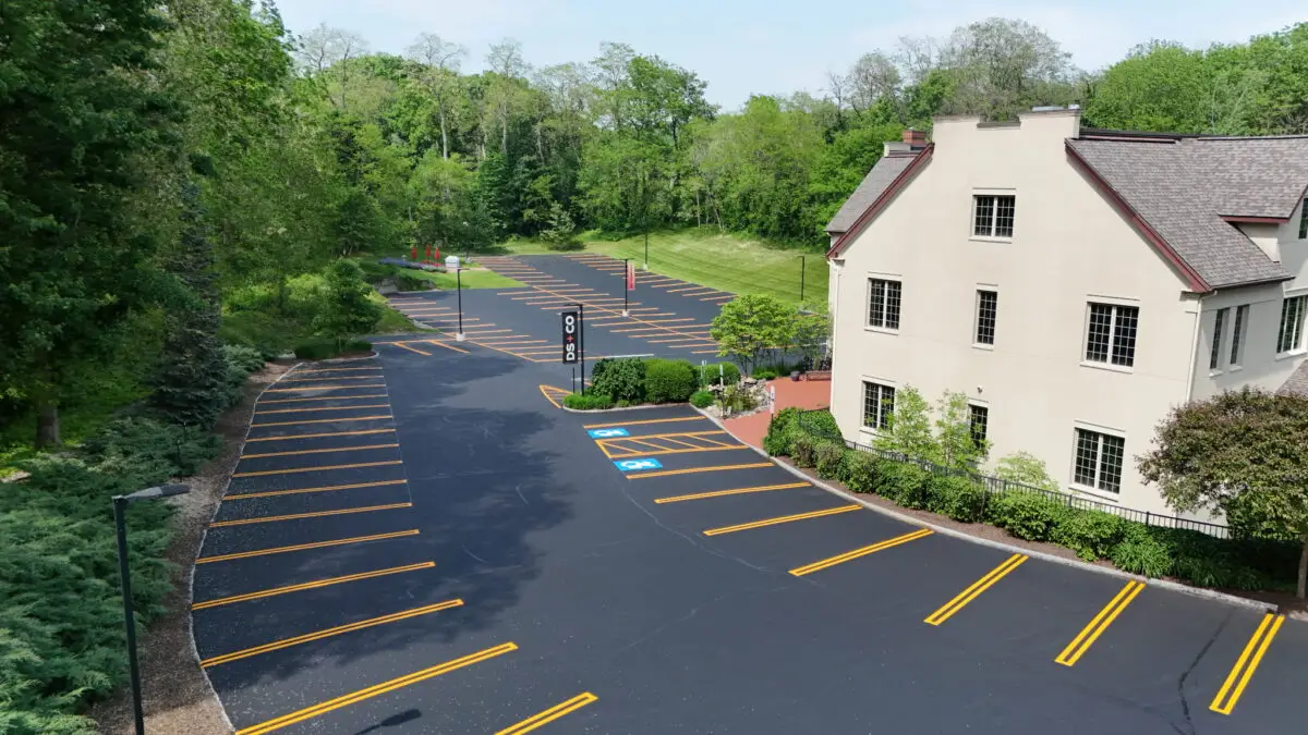Freshly coated and striped asphalt parking lot with handicap spaces, sealed using premium rubberized asphalt emulsion.